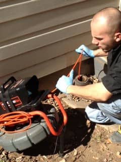man inspecting a pipe using a sewer camera