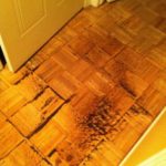 a wooden floor broken and warped from water damage