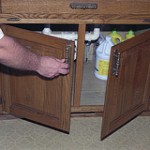 a man opening a small wooden cabinet