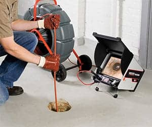 Male technician using sewer camera to inspect new home system