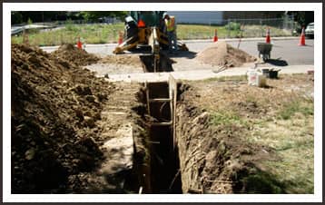 men working on a water line excavation