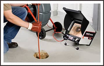 Male technician using sewer camera to inspect new home system