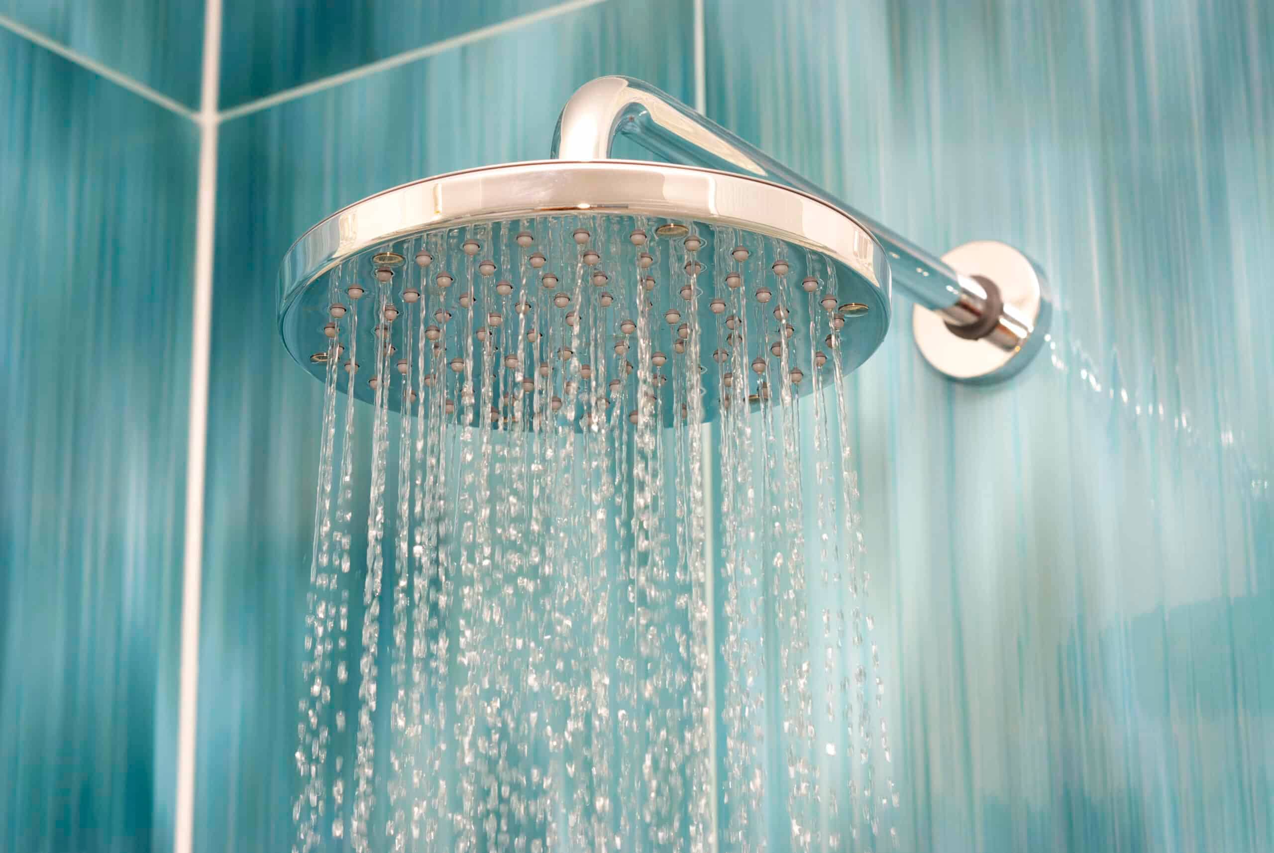 A chrome wall mounted shower head.
