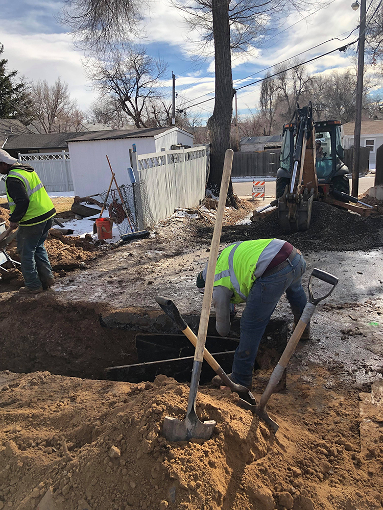 A Simply Sewers technician is working in a trench to repair a broken water line at an Evergreen, CO home.