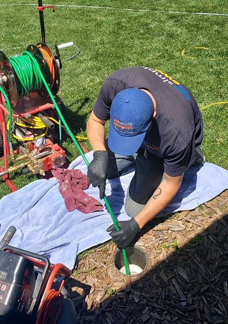 A plumber runs a sewer camera through the sewer pipes to determine the problem with the sewer line.