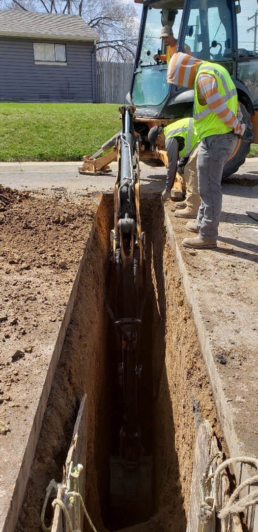 A plumbing crew is digging a trench to replace a sewer line in Aurora, CO 80017.