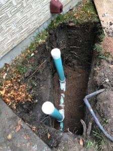 An outdoor sewer line access is being installed in the ground.